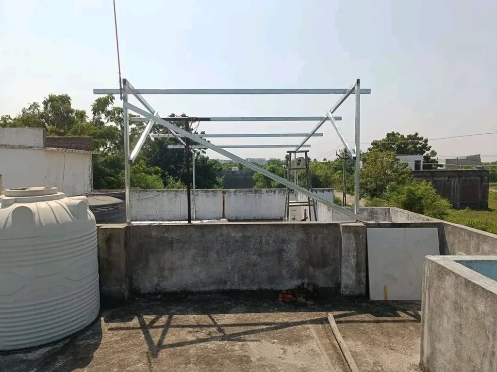 Elevated GI mounting structure on rooftop – SolarConnect India Elevated GI solar mounting structure installed on a flat concrete rooftop in India – SolarConnect rooftop solar project